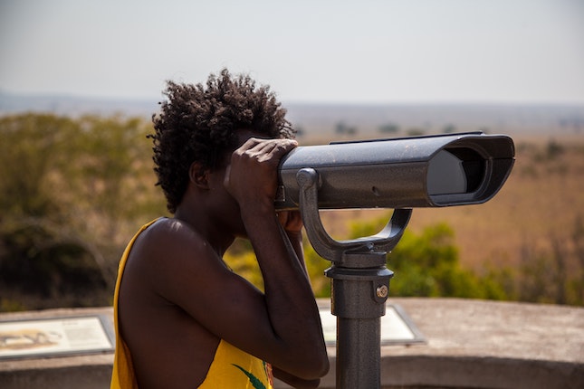 woman looking through telescope