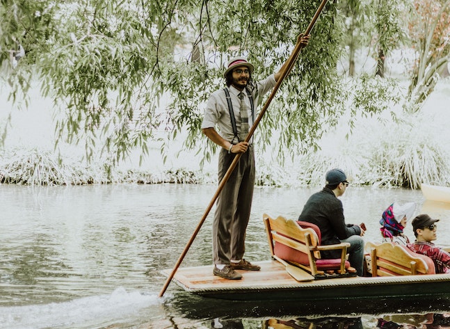 tour guide poling a raft on a river