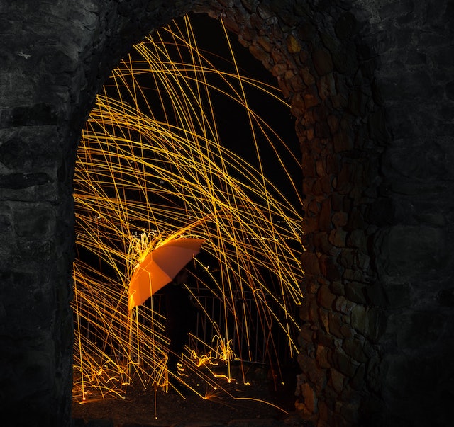 man holding umbrella in a shower of sparks