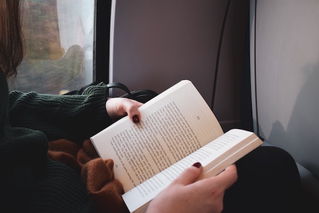 woman holding open book on her lap