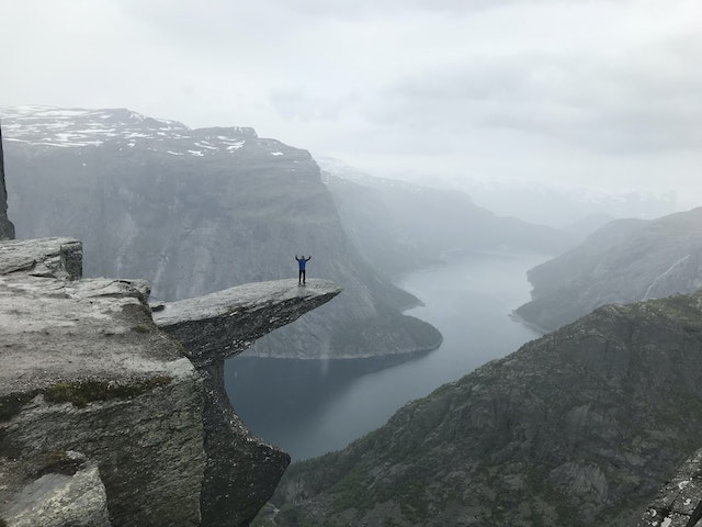 man standing on an overlook above a deep gorge