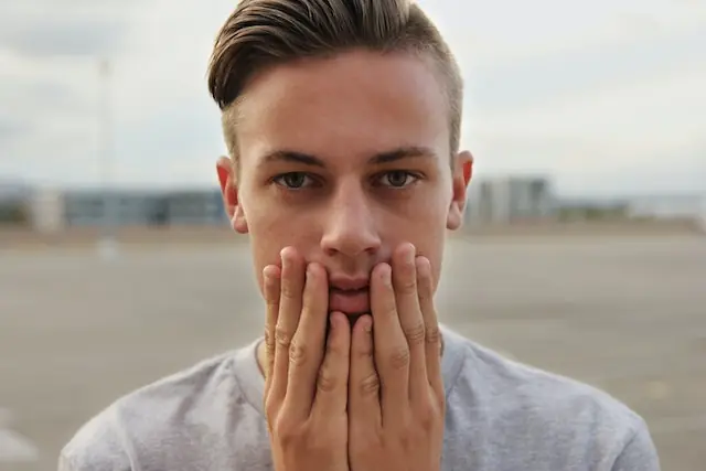 man with hands to face looking concerned