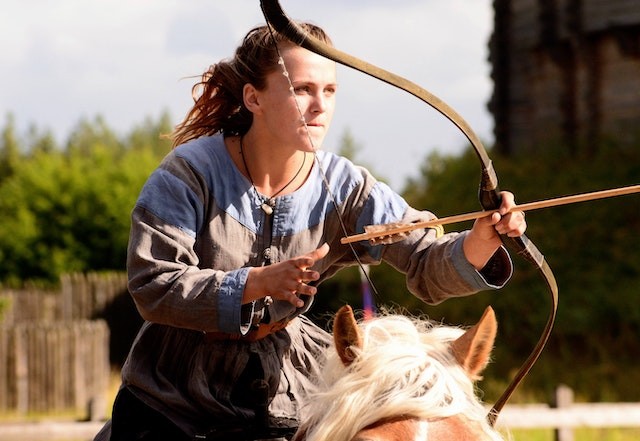 female horse archer aiming for target