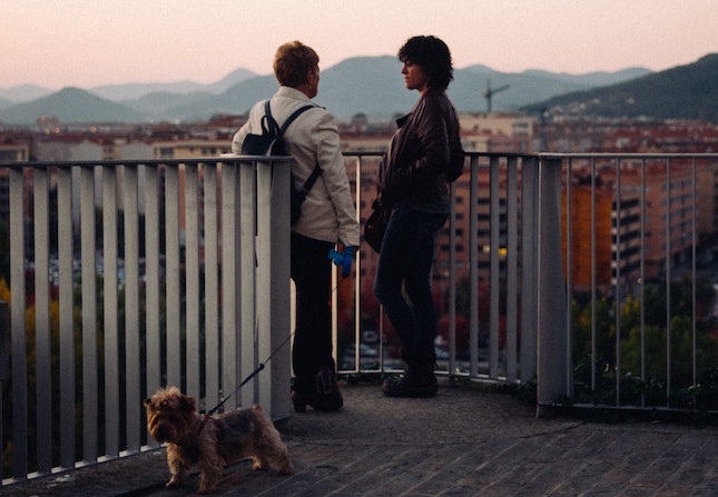 a man and woman in dialogue looking out over a city