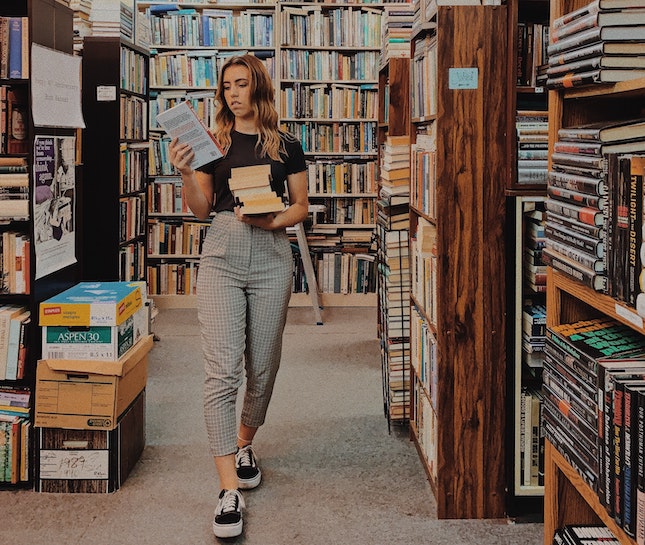 woman in bookstore looking at book title
