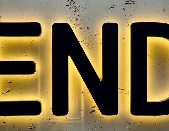 black letters spelling end backlit in yellow representing finishing a mystery novel