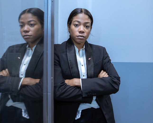 female police detective standing next to a mirror