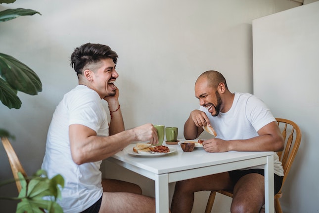two men at a table laughint