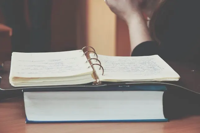 binder full of note pages illustrating a character bible