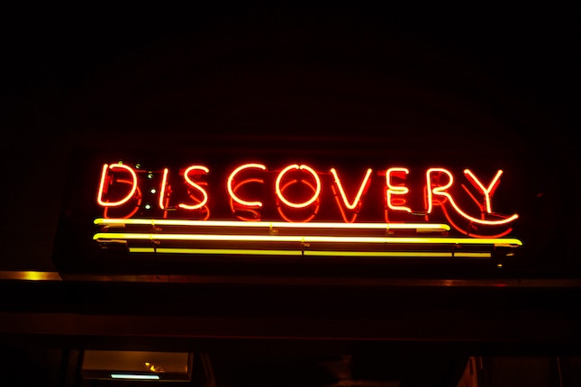 red neon sign of the word discovery