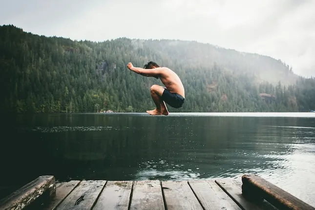 boy civing into a lake