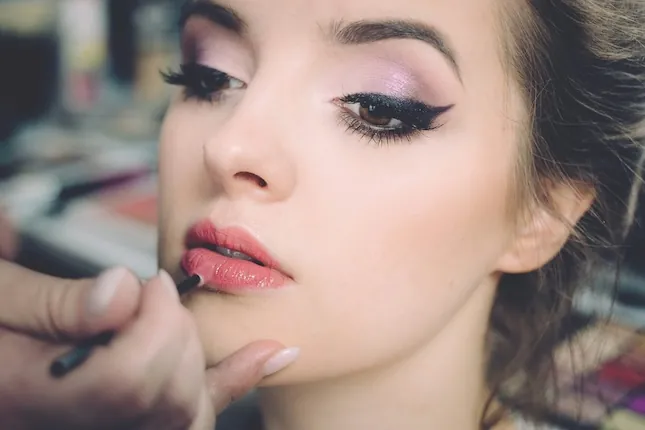 woman applying makeup to her face