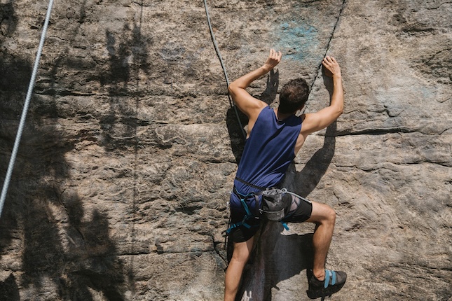 man rock climbing to illustrate persistence